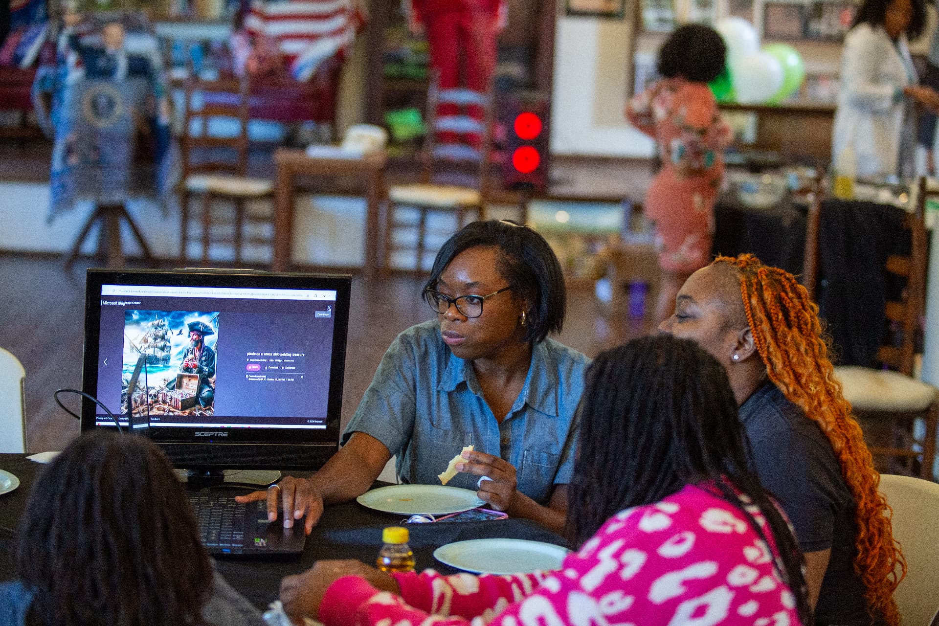 Participants explore digital design tools on a computer while enjoying snacks during STEM Day.