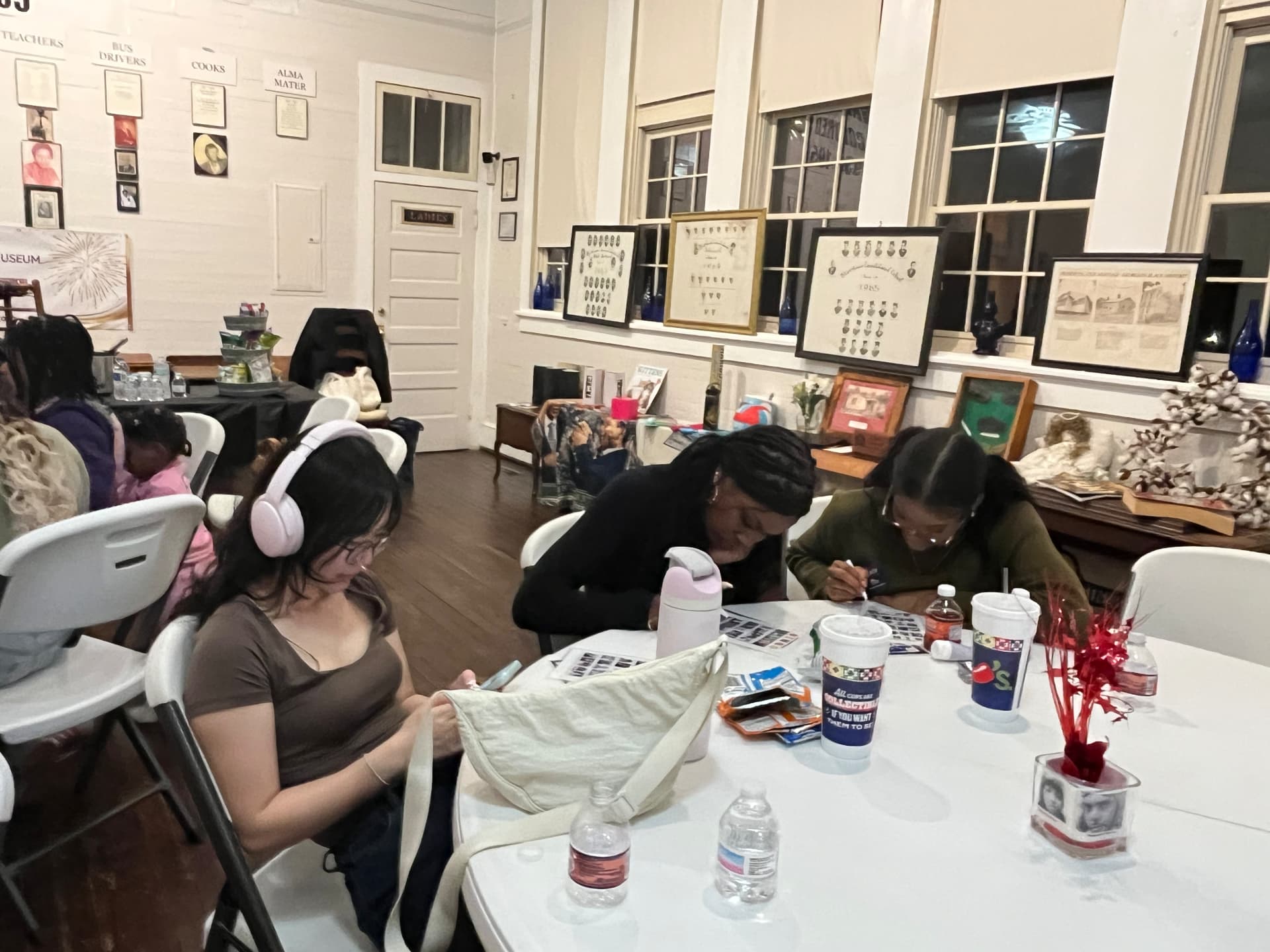 Guests fill out bingo cards at a table near the museum's museum displays and vintage class portraits.