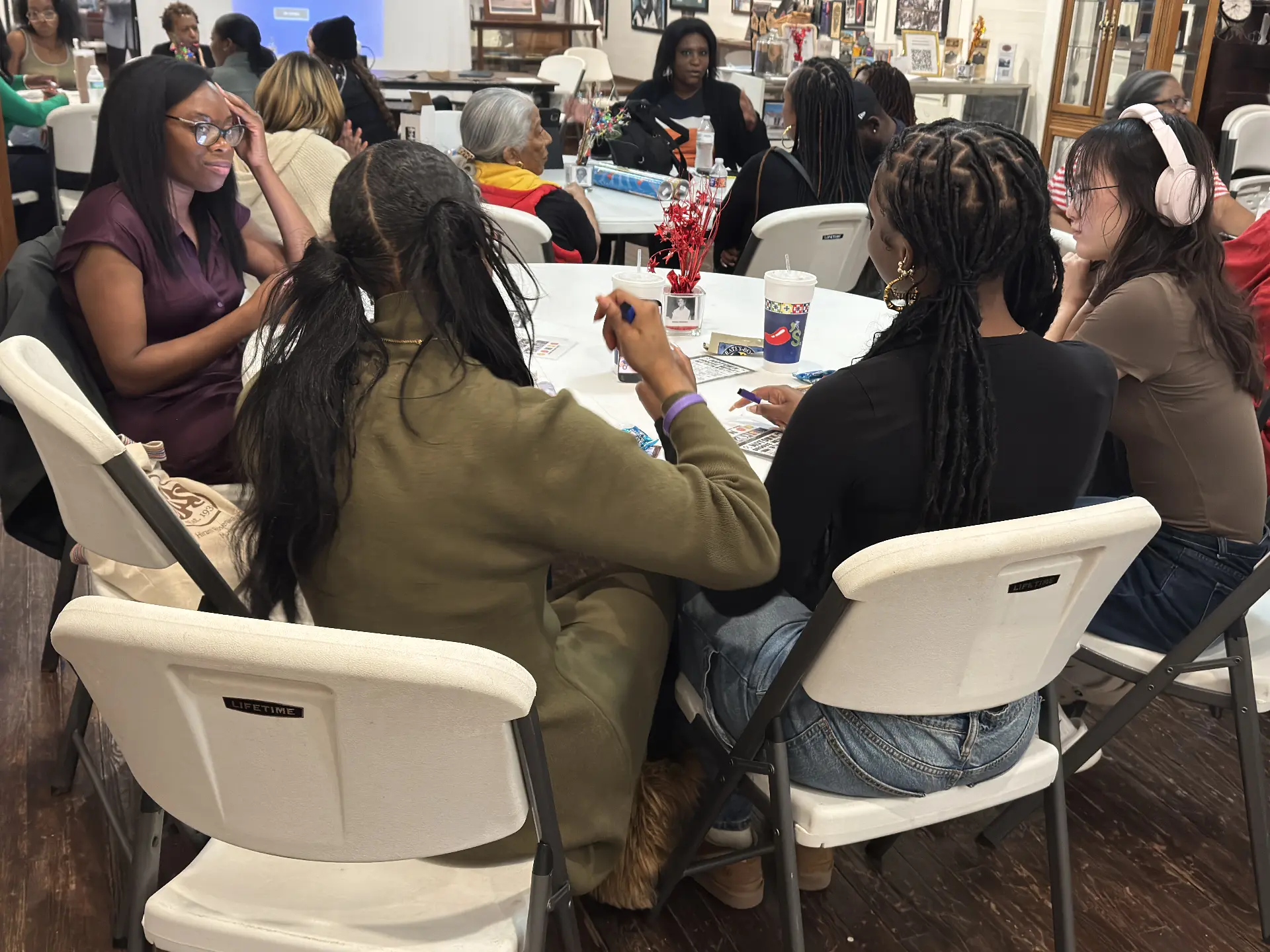Guests chat and check their cards at a table during the Black History Game Night program.