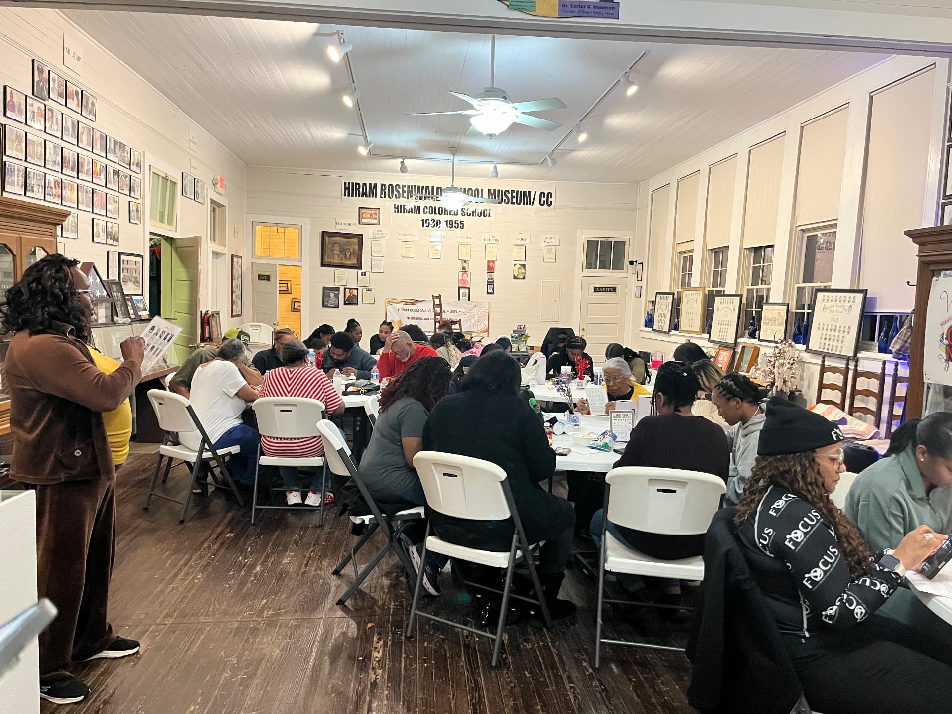 A full room of guests playing games around tables inside the museum during Black History Game Night.