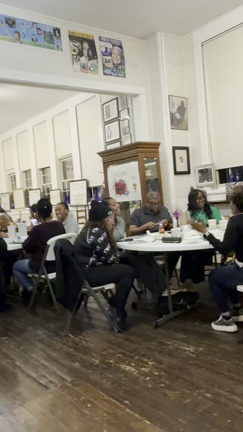 Guests laugh and enjoy the evening together at a round table during Black History Game Night.