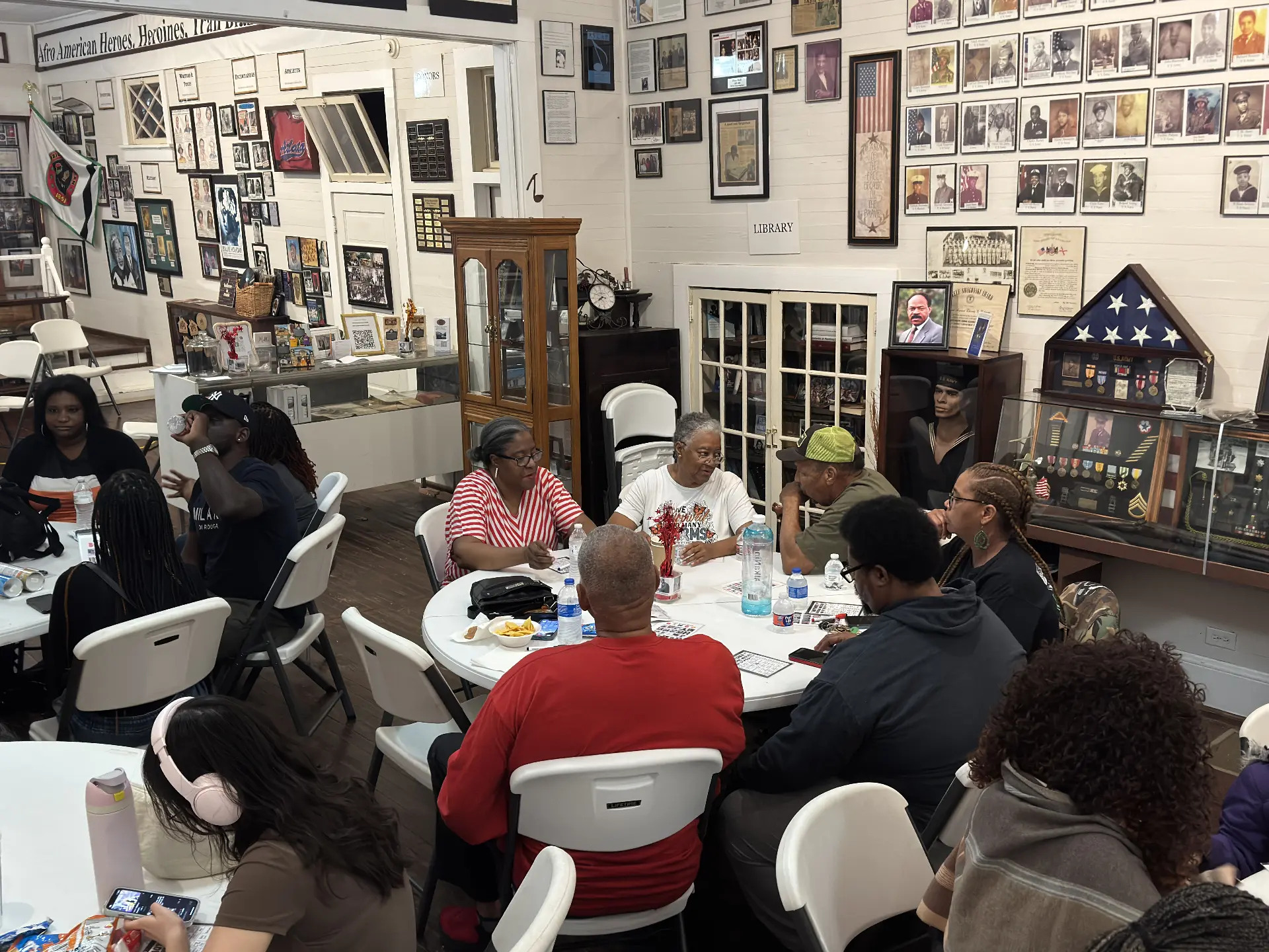 Guests play bingo around a table surrounded by the museum's military heroes displays and library.