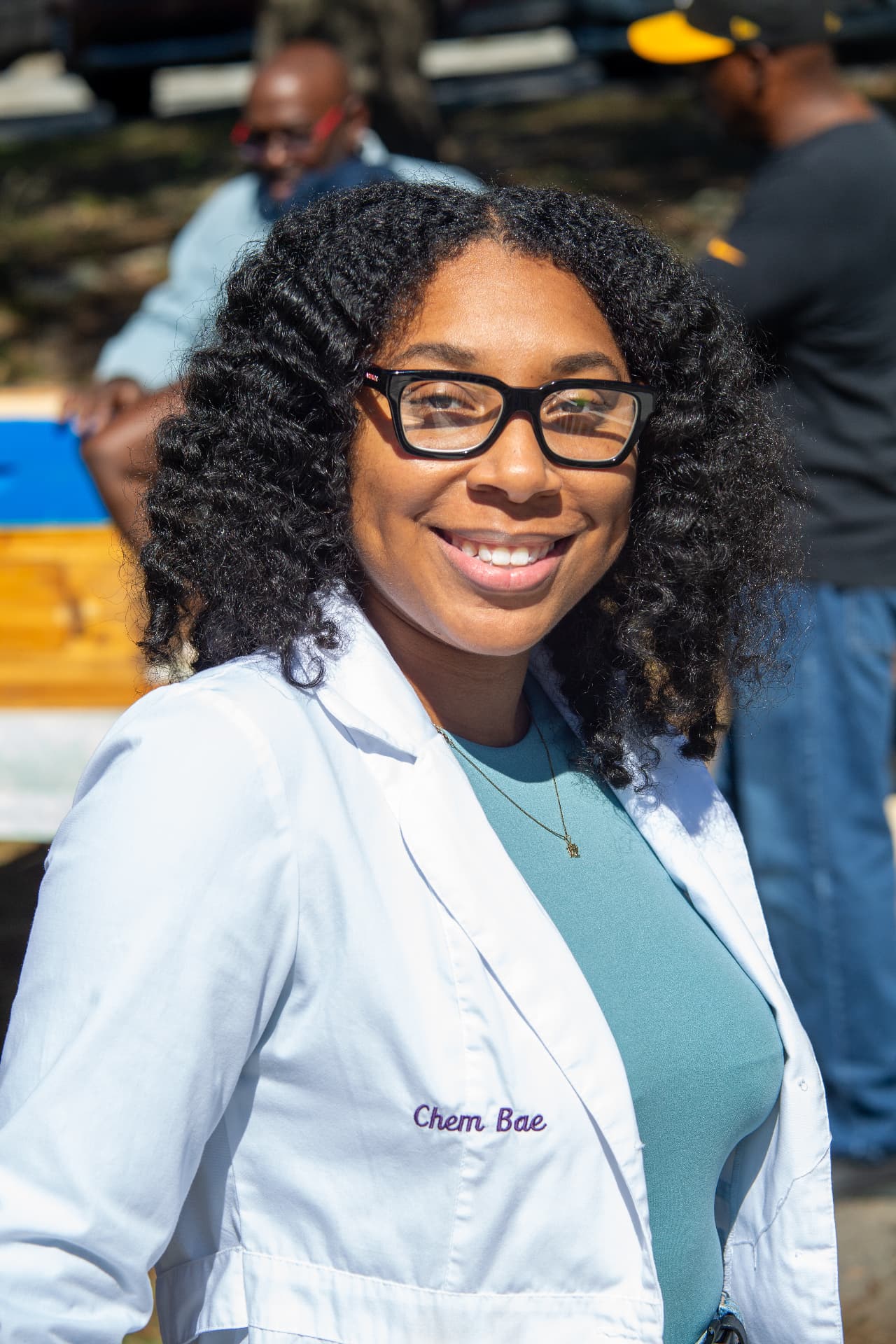 A portrait of the guest scientist smiling in her white lab coat during STEM Day.