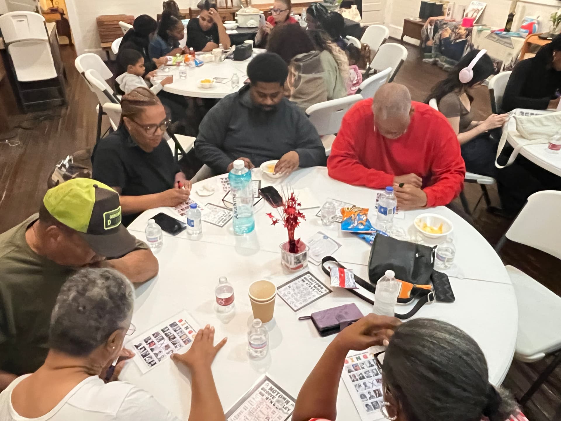 Families share snacks and play Black History Medley Bingo at round tables inside the museum.