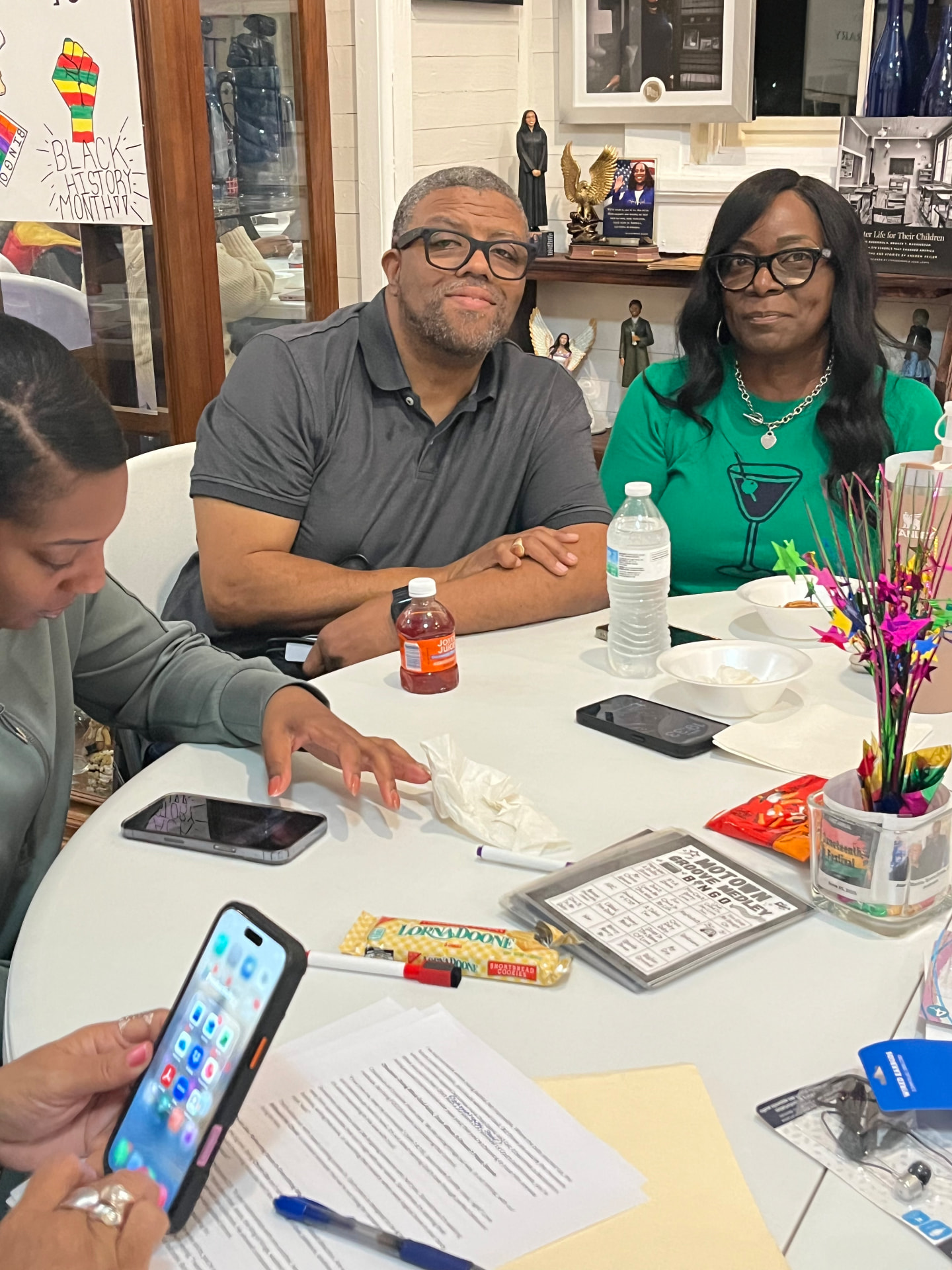 Two guests smile while playing Motown Groove'n Bingo at a table decorated for Black History Month.